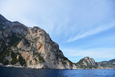 Kayalar ve deniz mavi gökyüzü altında