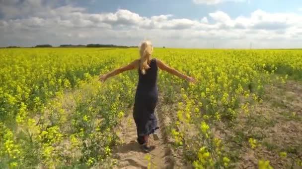 Giovane donna bionda in posa in un bellissimo campo di colza — Video Stock