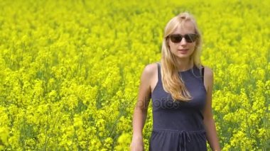 Genç sarışın kadın güzel kolza tohumu alanında poz