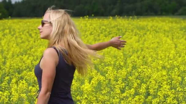 Jovem mulher loira posando em belo campo de colza — Vídeo de Stock