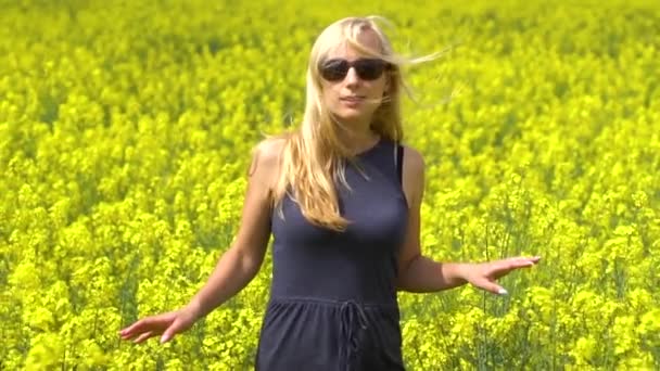 Jeune femme blonde posant dans le beau champ de colza — Video