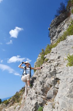 kadın dağın zirveye tırmanıyor.