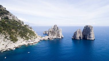 Kayalar ve deniz mavi gökyüzü altında