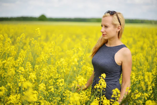 Žena v poli řepky — Stock fotografie