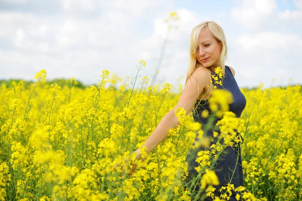 Kvinna på fältet av raps — Stockfoto