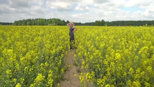 젊은 금발 여 자가 아름 다운 유채 밭에서 포즈 — 비디오