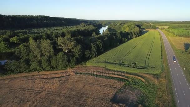 Vliegen boven de weg in velden — Stockvideo