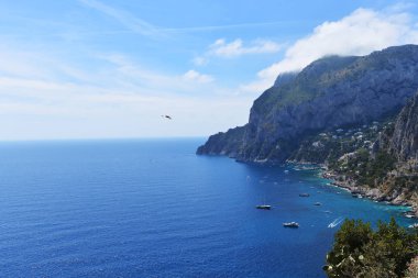 Kayalar ve deniz mavi gökyüzü altında