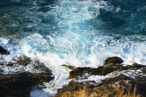 Волны брызгают камнями — стоковое фото