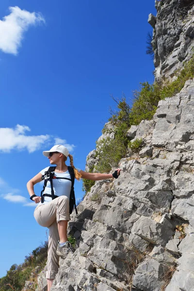 Kobieta wspina się po zboczu góry — Zdjęcie stockowe