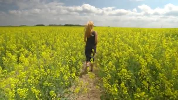 Joven rubia posando en hermoso campo de colza — Vídeo de stock