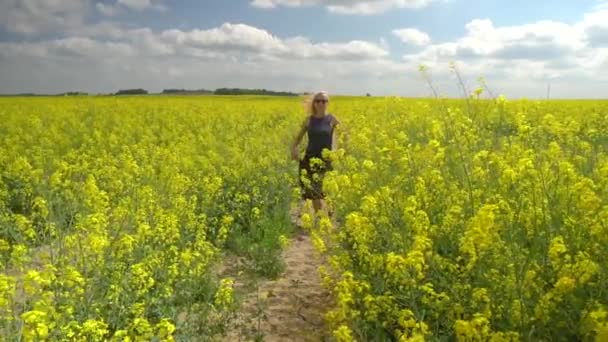 Giovane donna bionda in posa in un bellissimo campo di colza — Video Stock