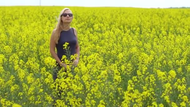 Genç sarışın kadın güzel kolza tohumu alanında poz — Stok video