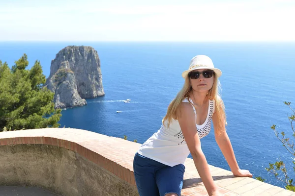 Şapkalı kadın taş diken üstünde oturuyor