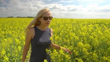 Genç sarışın kadın güzel kolza tohumu alanında poz