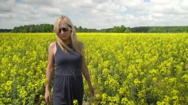 Genç sarışın kadın güzel kolza tohumu alanında poz