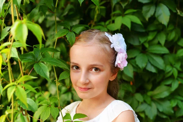 Menina bonito com grampos de cabelo flor — Fotografia de Stock