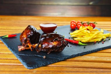 kızarmış patates ve domuz kemik ile taş tahtaya servis