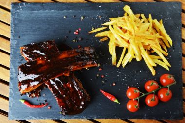 kızarmış patates ve domuz kemik ile taş tahtaya servis