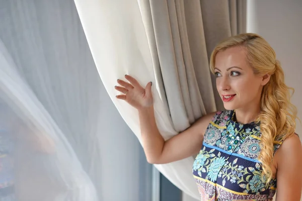 Frau Mit Blonden Haaren Schaut Durch Fenster — Stockfoto