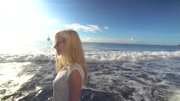 Vrouw die langs het strand loopt — Stockvideo