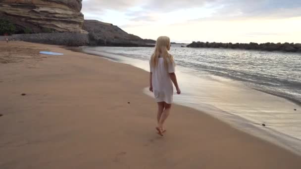 Vrouw die langs het strand loopt — Stockvideo