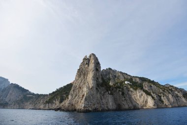 Kayalar ve deniz mavi gökyüzü altında