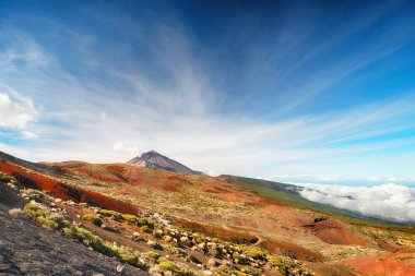 Volkanın tepesine yukarıda bulutlu gökyüzü