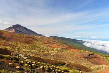 Volkanın tepesine yukarıda bulutlu gökyüzü