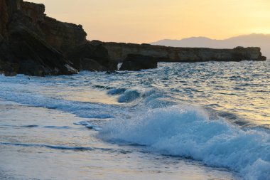 su sıçramalarına taşlar üzerinde deniz kıyısı, günbatımında dalgalar