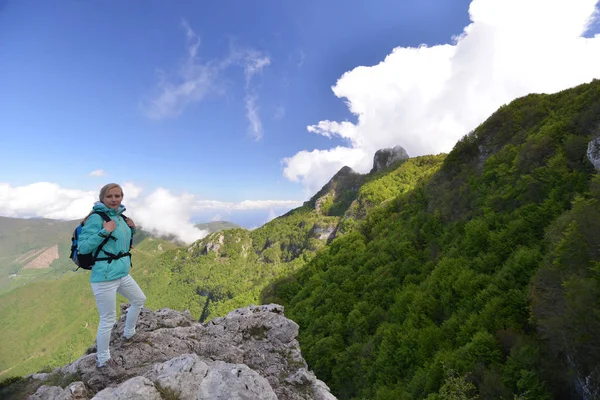 Žena stojí na vrcholu hory — Stock fotografie