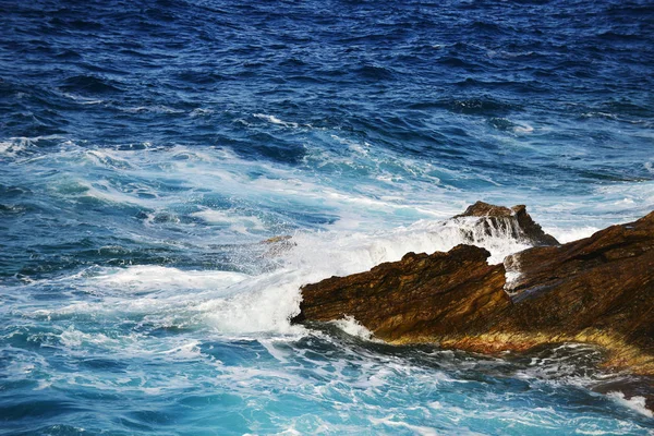 Ondas salpicando em pedras — Fotografia de Stock