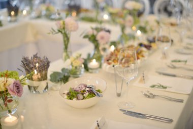 Düğün resepsiyonu misafirler için hazır. Yemek ve içecek dolu bir masa.