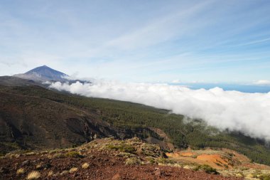 Mavi gökyüzünün altında dağın tepesine bakış