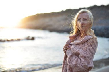 akşam manzara. güzel kadın deniz kıyısı yürüyor