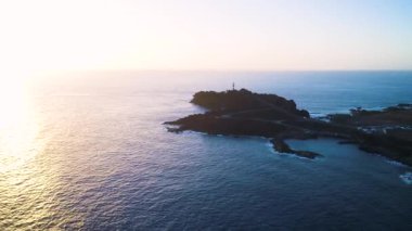 Deniz feneri günbatımı sırasında havadan görünümü
