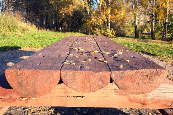 Длинный деревянный стол из бревен в парке — стоковое фото