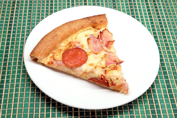 Appetizing pizza piece on a plate closeup — Stock Photo, Image