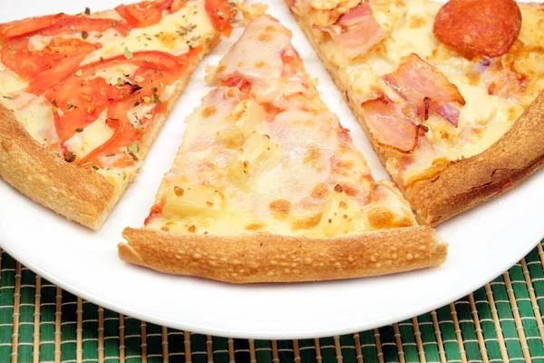Аппетитный кусок пиццы на тарелке крупным планом — стоковое фото