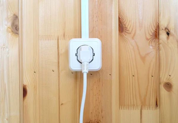 Tomada elétrica branca na tomada na parede de madeira com pranchas verticais — Fotografia de Stock