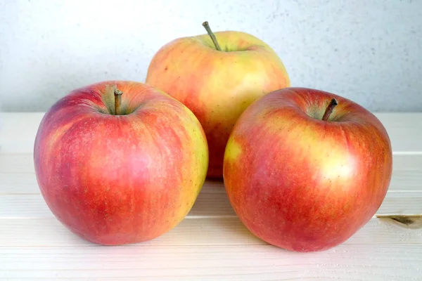 Three big ripe apples on wooden shelf — Stock Photo, Image