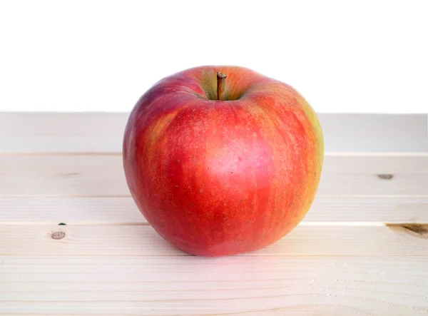 Big ripe red apple in beige wooden shelf closeup — Stock Photo, Image