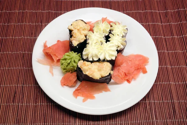 Sushi op witte plaat over stro rieten mat closeup — Stockfoto