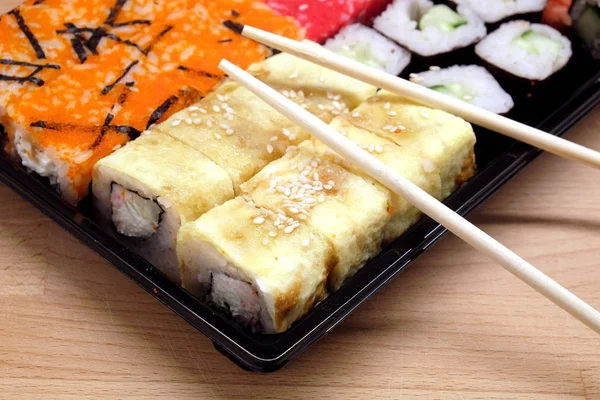 Sushi na čtvercový zásobník na hnědý dřevěný stůl boční pohled closeup — Stock fotografie