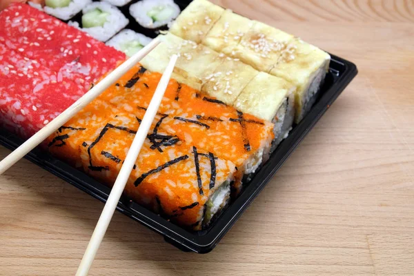 Sushi su vassoio quadrato su tavolo di legno marrone vista laterale primo piano — Foto Stock