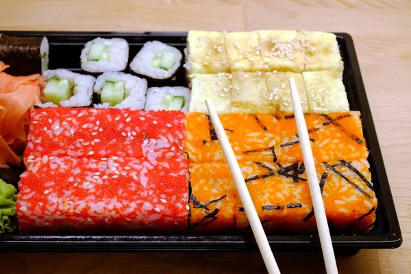 Sushi op vierkante dienblad op bruin houten tafel kant weergave closeup — Stockfoto
