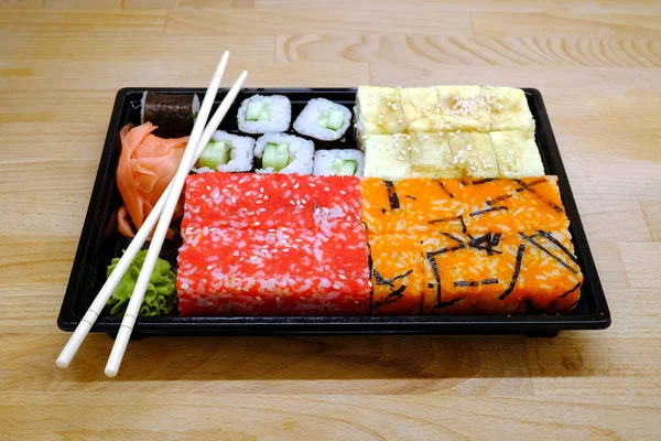 Sushi na čtvercový zásobník na hnědý dřevěný stůl boční pohled closeup — Stock fotografie