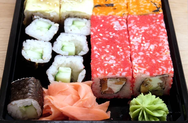 Sushi op vierkante dienblad op bruin houten tafel kant weergave closeup — Stockfoto
