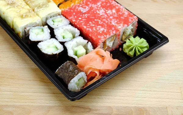 Sushi na čtvercový zásobník na hnědý dřevěný stůl boční pohled closeup — Stock fotografie