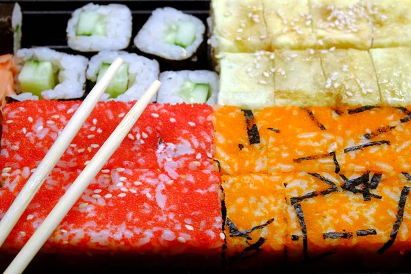 Sushi na čtvercový zásobník na hnědý dřevěný stůl boční pohled closeup — Stock fotografie